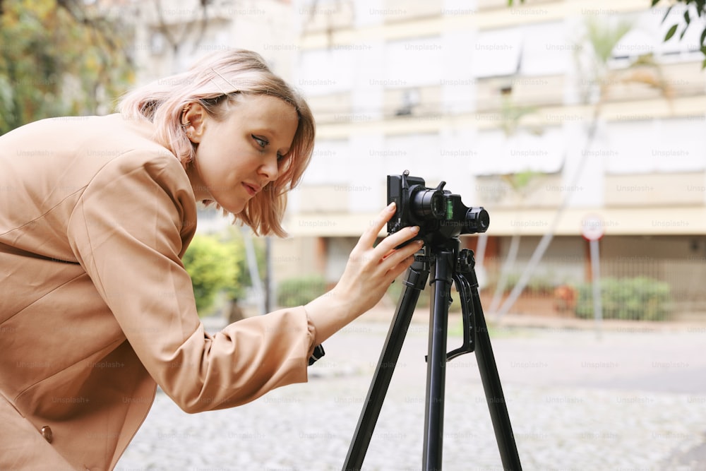 a woman taking a picture with a camera on a tripod