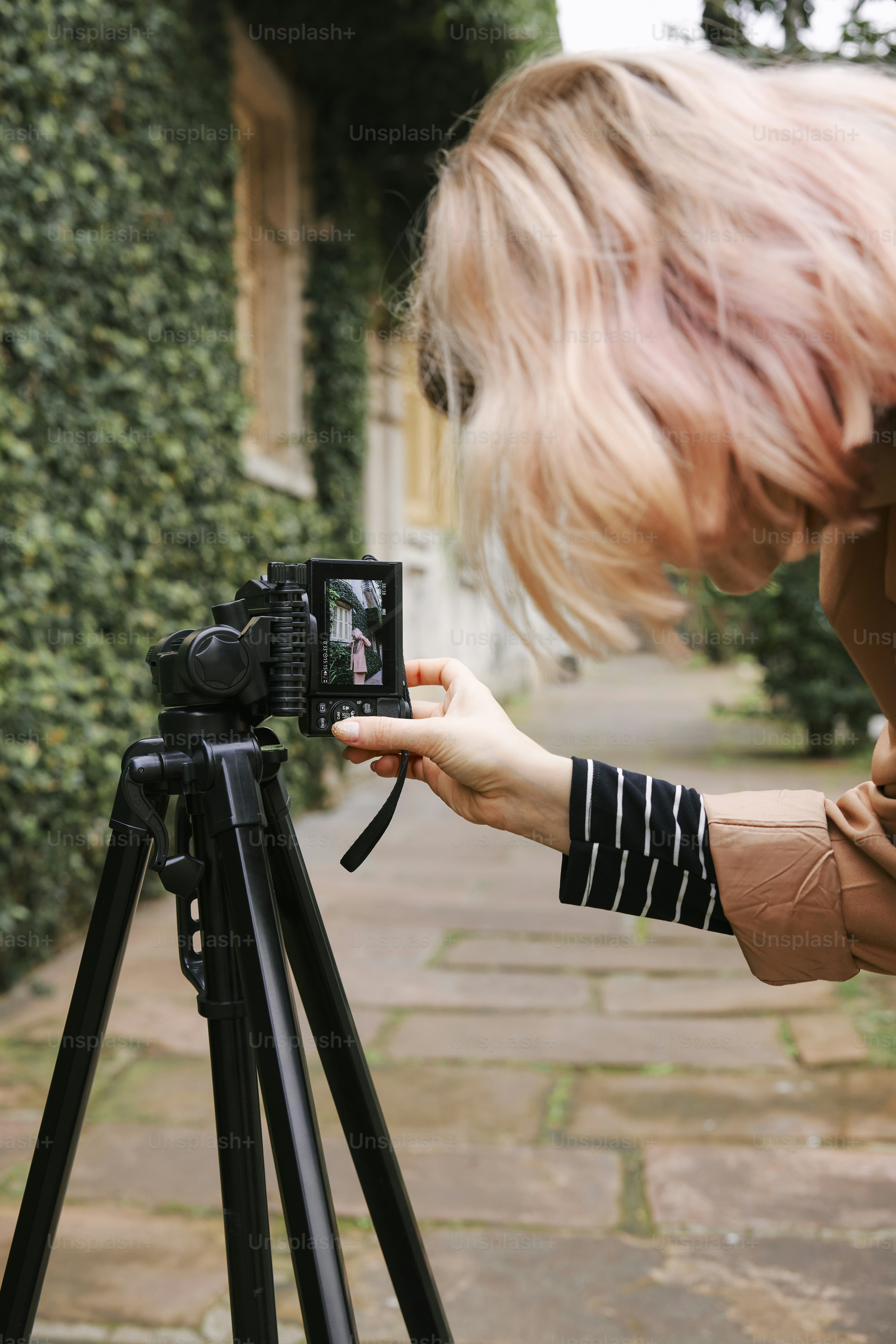 uma mulher tirando uma foto com uma câmera em um tripé
