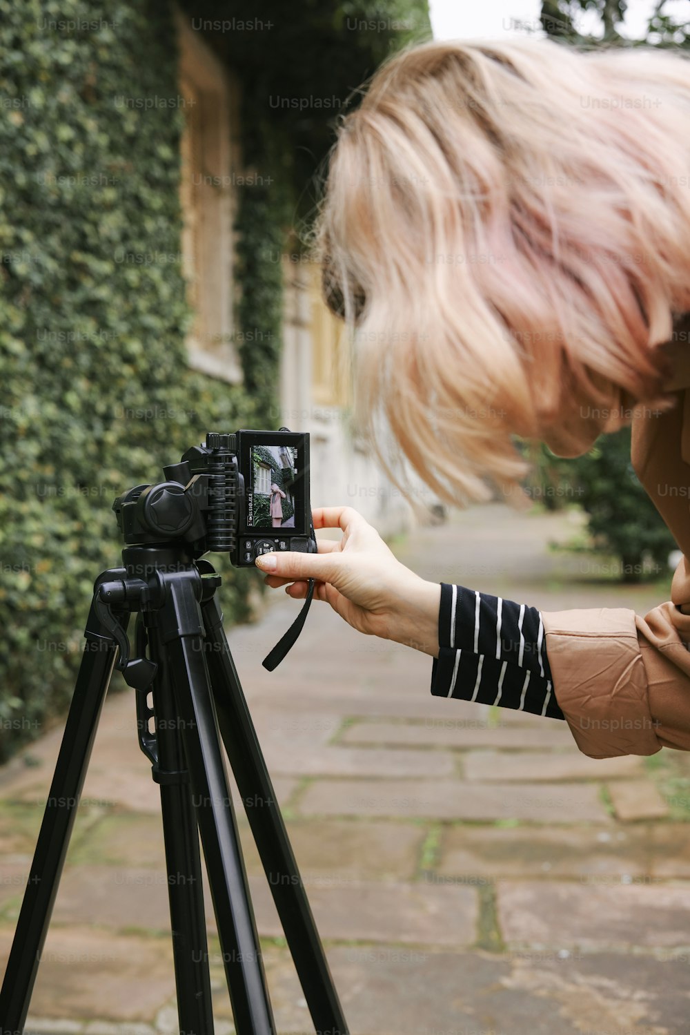 uma mulher tirando uma foto com uma câmera em um tripé
