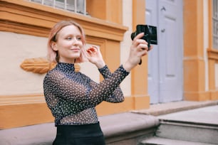 a woman taking a picture of herself with a camera