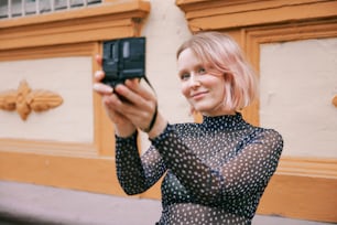 uma mulher tirando uma foto com seu celular