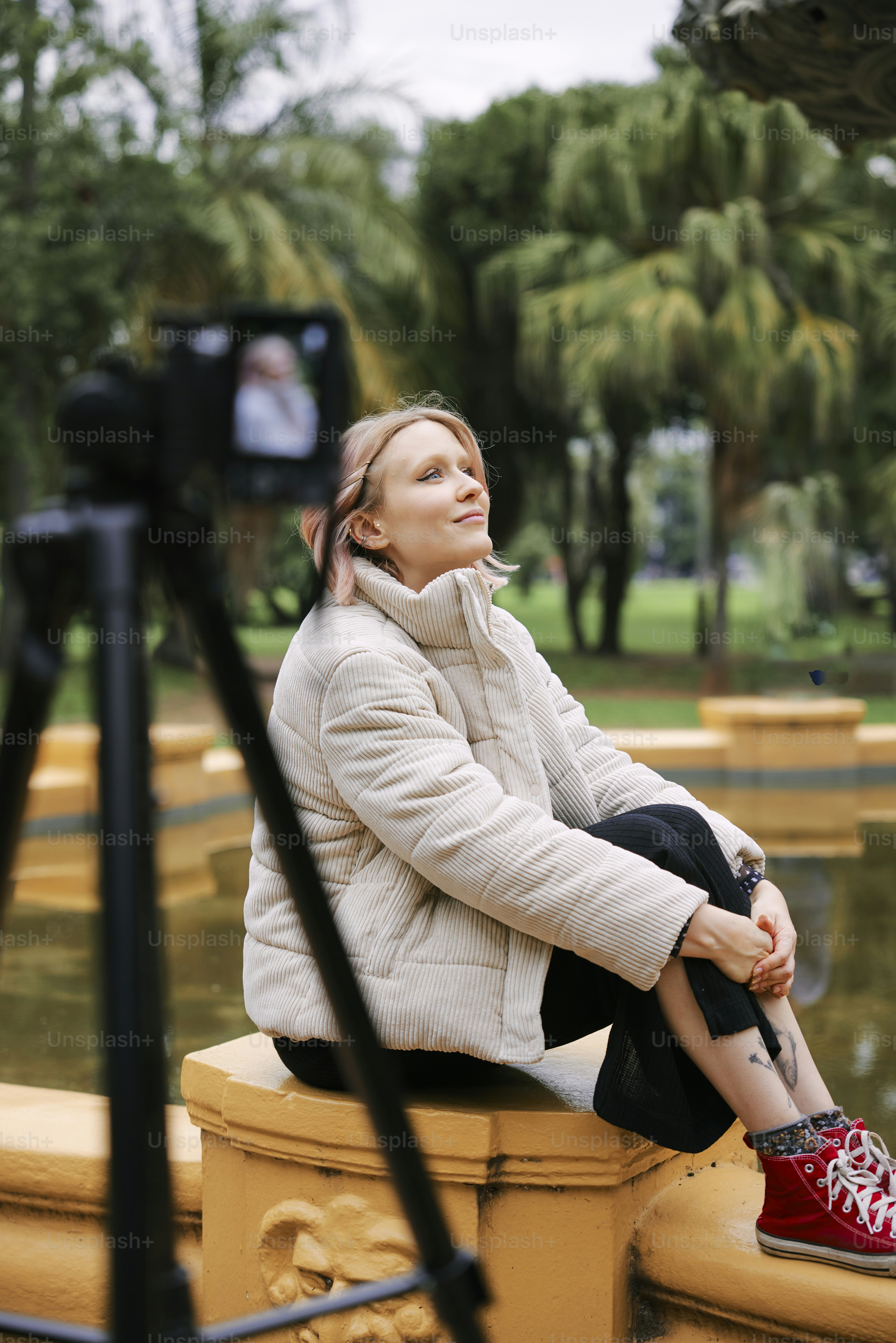 a woman sitting on top of a yellow pillar