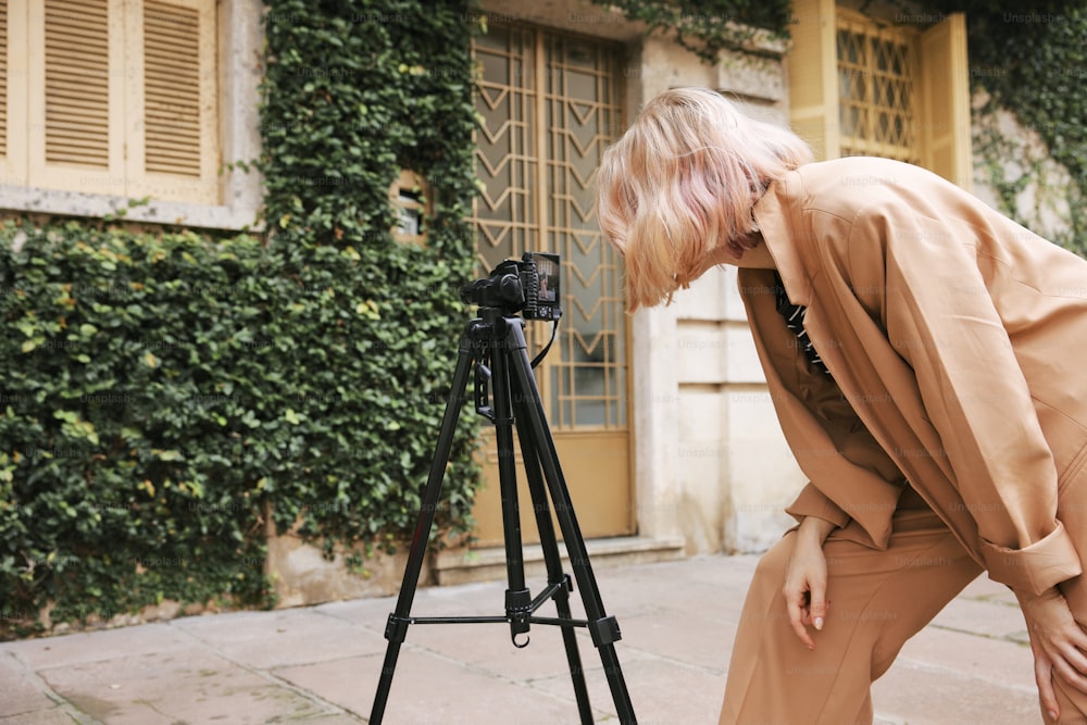 a woman leaning over a camera on a tripod