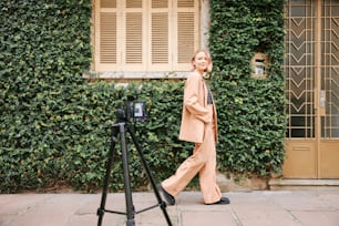 a woman walking down a sidewalk next to a camera