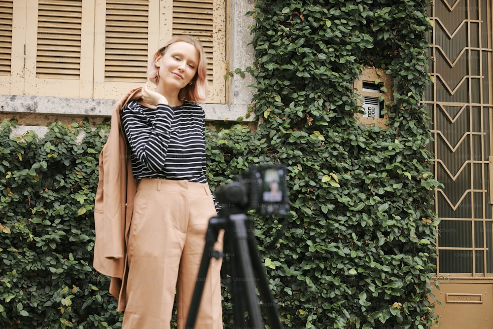 a woman standing in front of a green wall