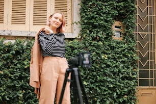 a woman standing in front of a green wall