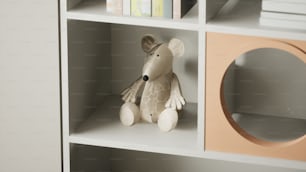 une souris jouet assise au-dessus d’une étagère à livres