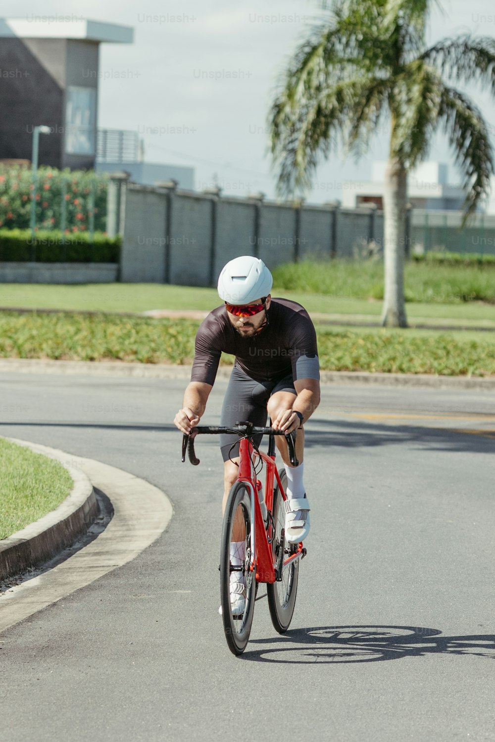 um homem andando de bicicleta vermelha por uma rua