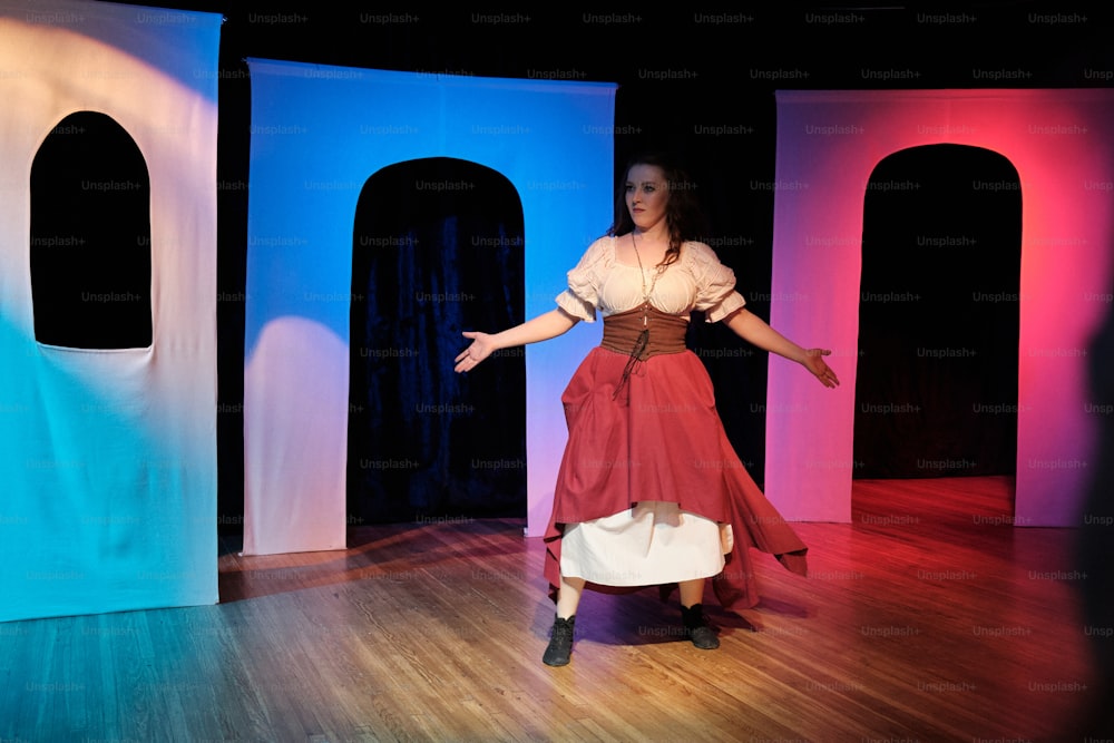 Eine Frau in einem roten Kleid tanzt auf einer Bühne