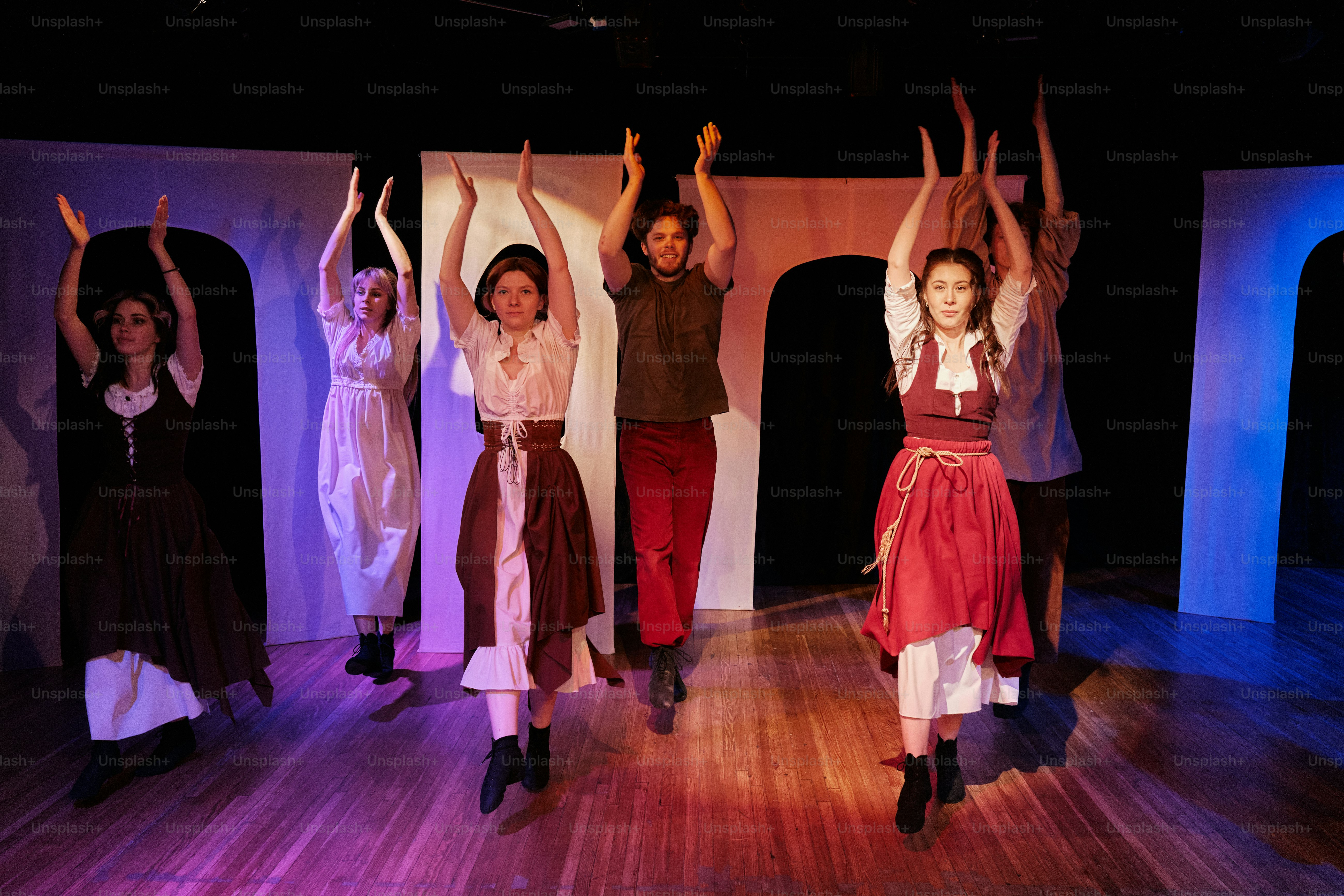 a group of people standing on top of a wooden floor