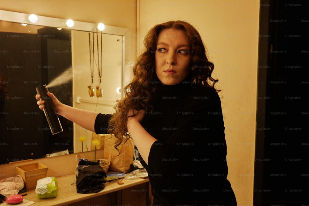 Une femme se séchant les cheveux devant un miroir