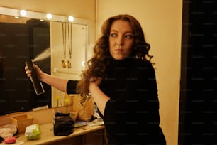 uma mulher secando o cabelo em frente a um espelho