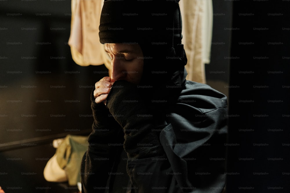 a man in a black hoodie is looking at his cell phone