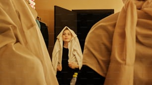 uma mulher em pé em frente a um espelho em uma sala
