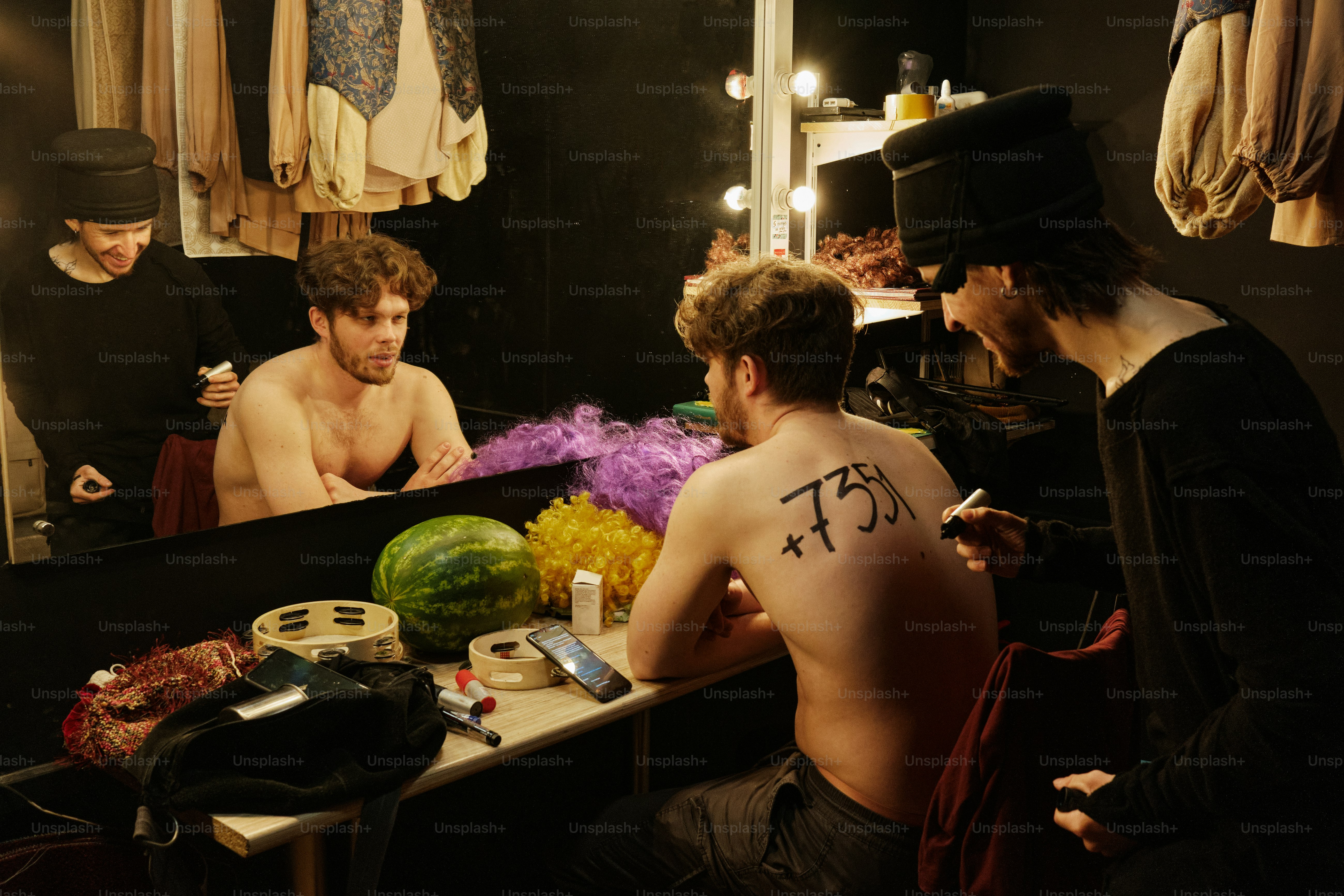 a group of men sitting around a table in front of a mirror