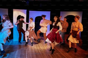 a group of people standing on top of a wooden floor