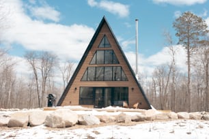 a wooden house with a triangular roof in the snow