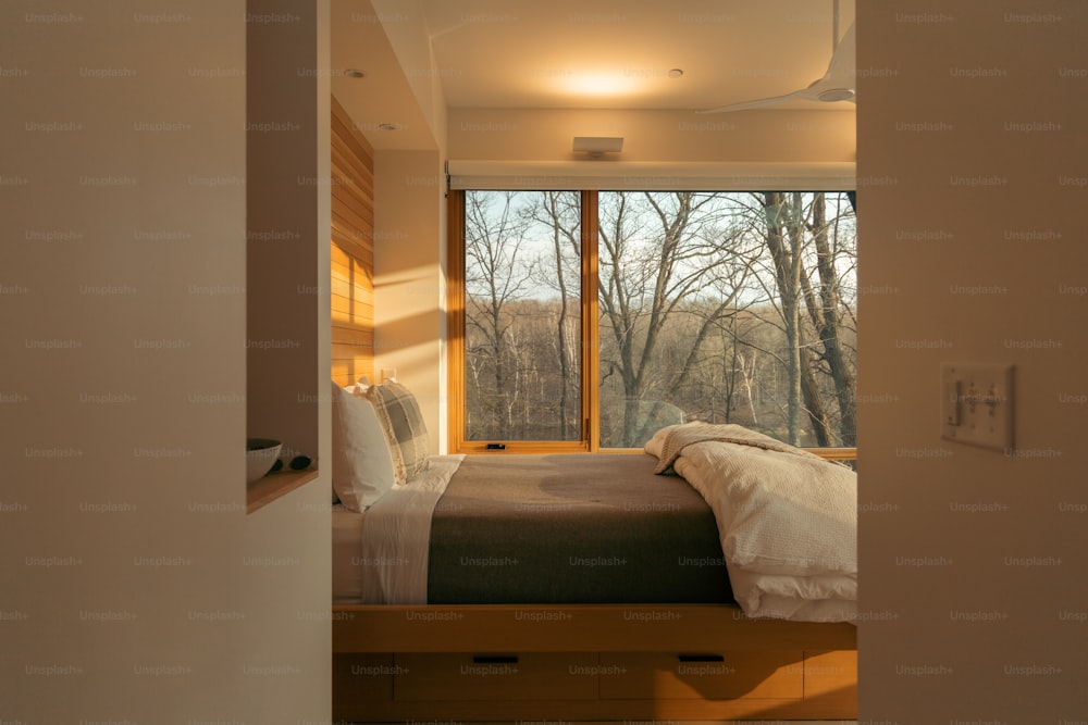 une chambre avec un lit et une grande fenêtre