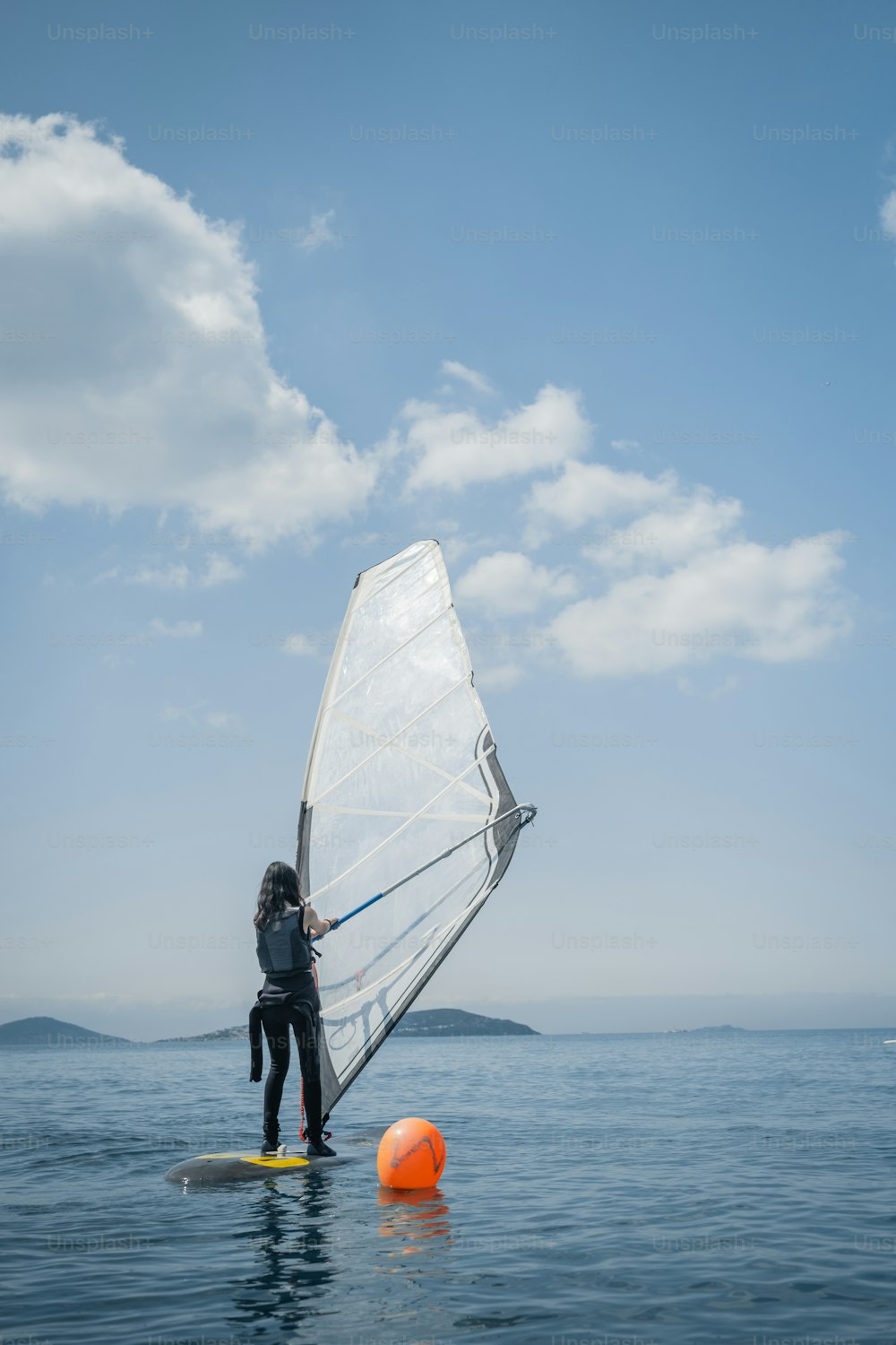a person on a surfboard with a sail