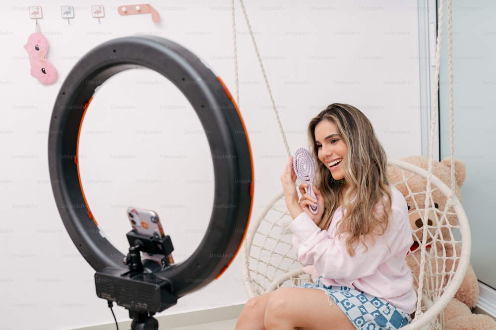 a woman sitting in a chair holding a cell phone