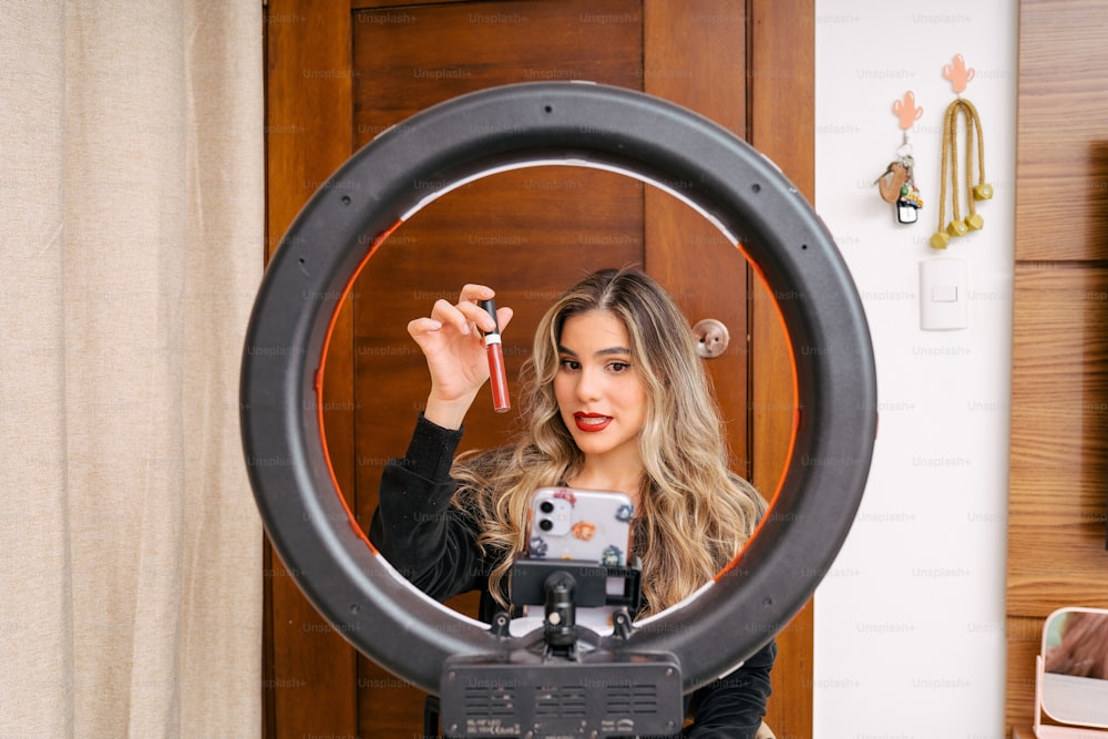 a woman holding a camera in front of a mirror