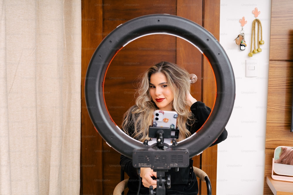 una donna che tiene una macchina fotografica davanti a uno specchio