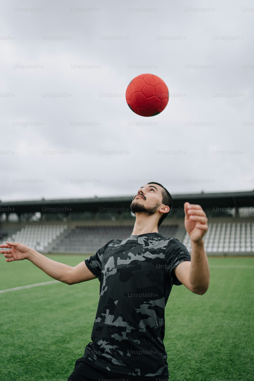 um homem jogando uma bola vermelha no ar