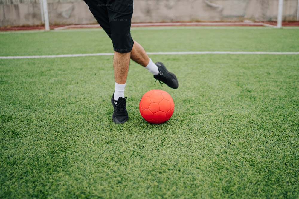 a man kicking a soccer ball on a soccer field