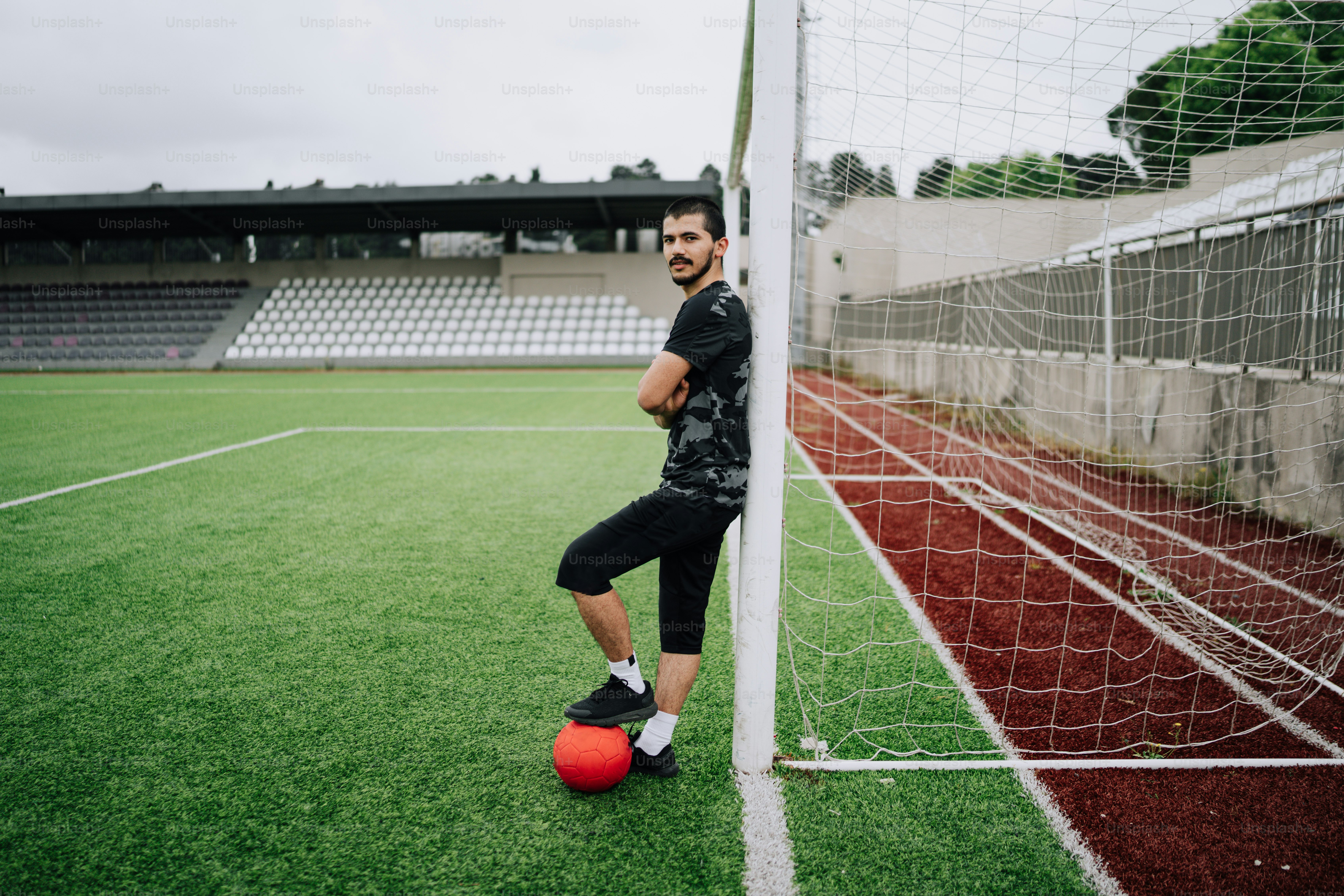 a man standing next to a soccer ball on a field