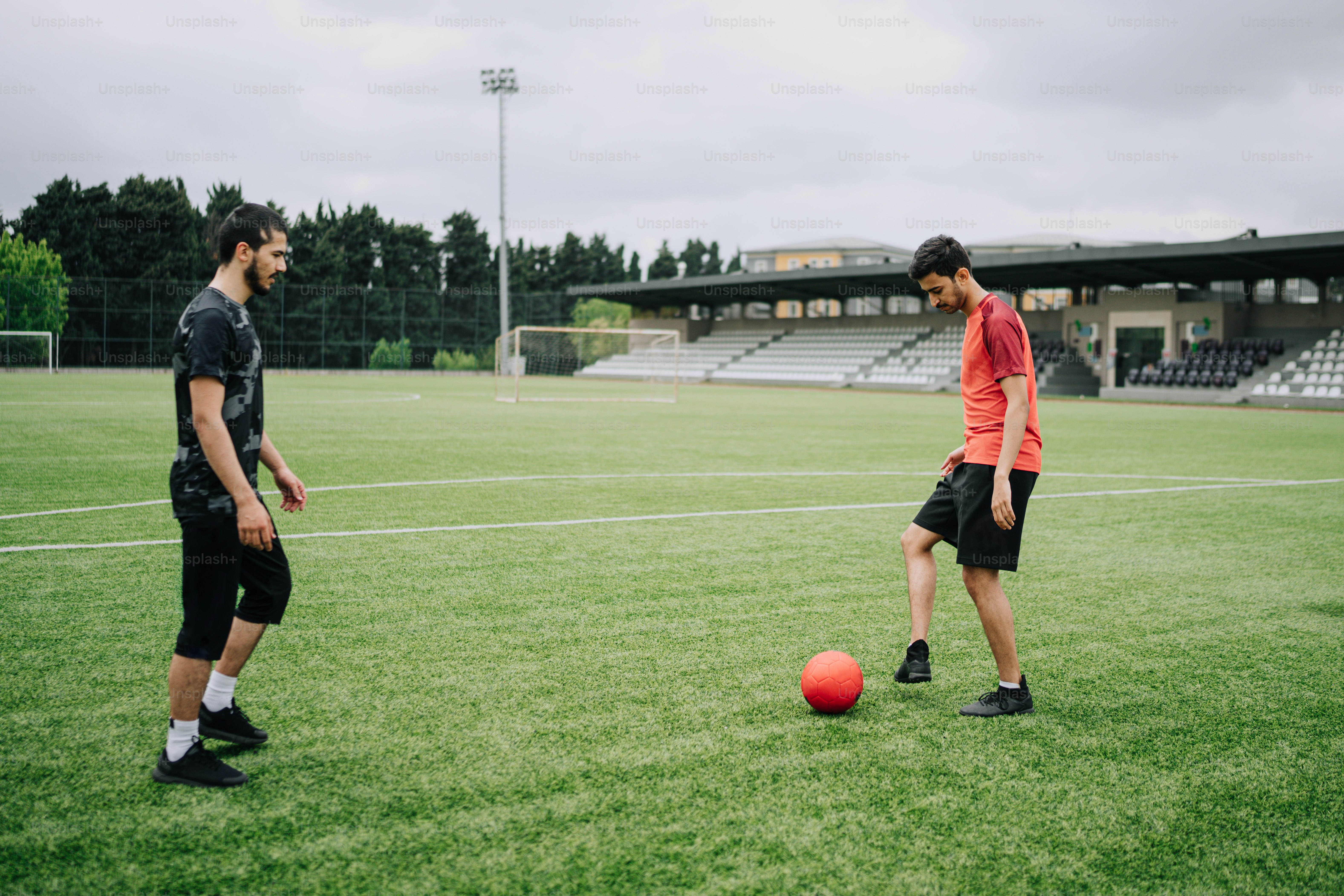 a couple of men standing on top of a soccer field