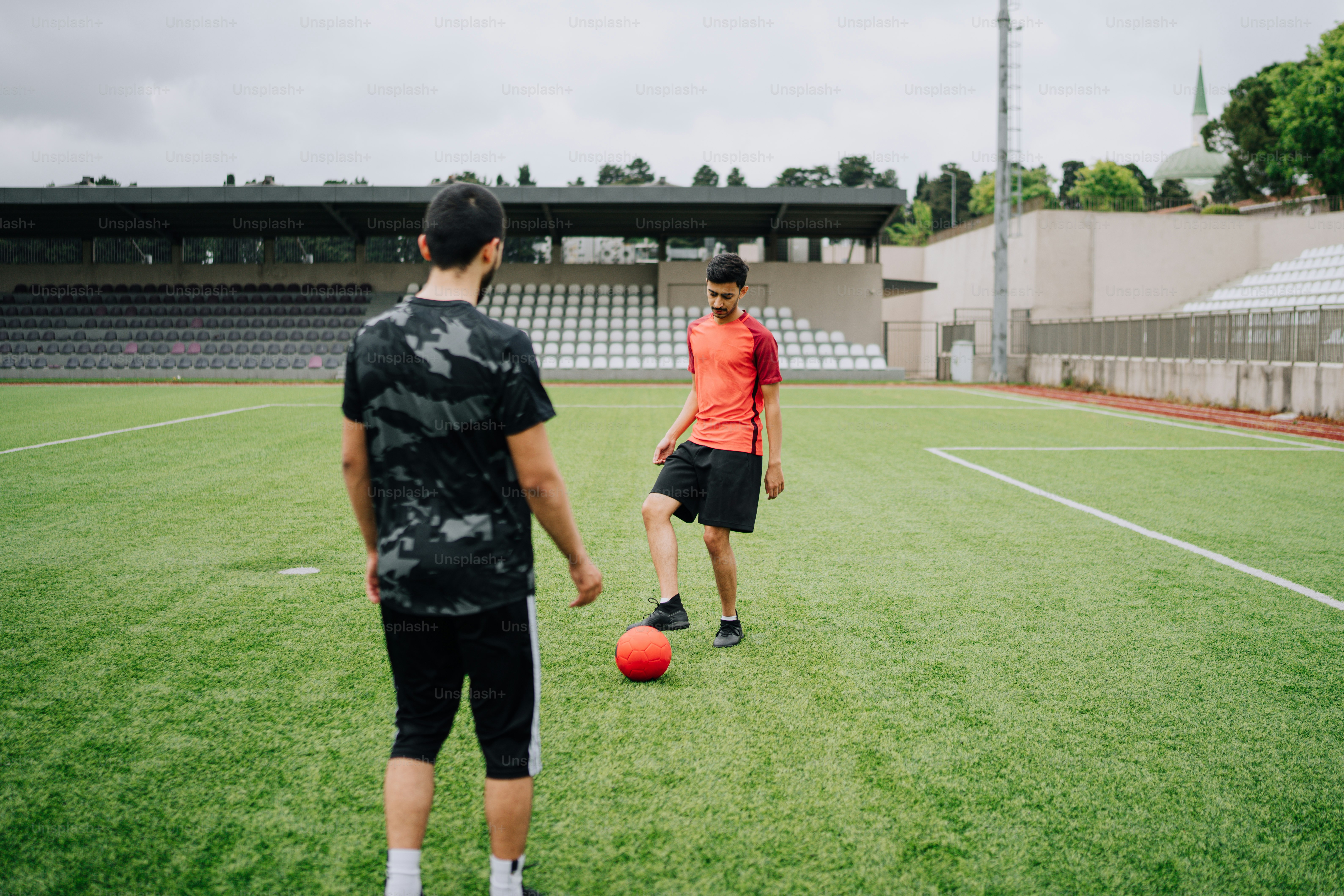 a couple of men standing on top of a soccer field
