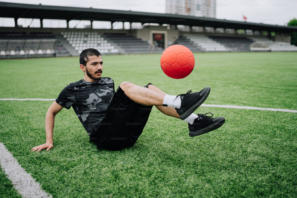 a man laying on the ground with a soccer ball