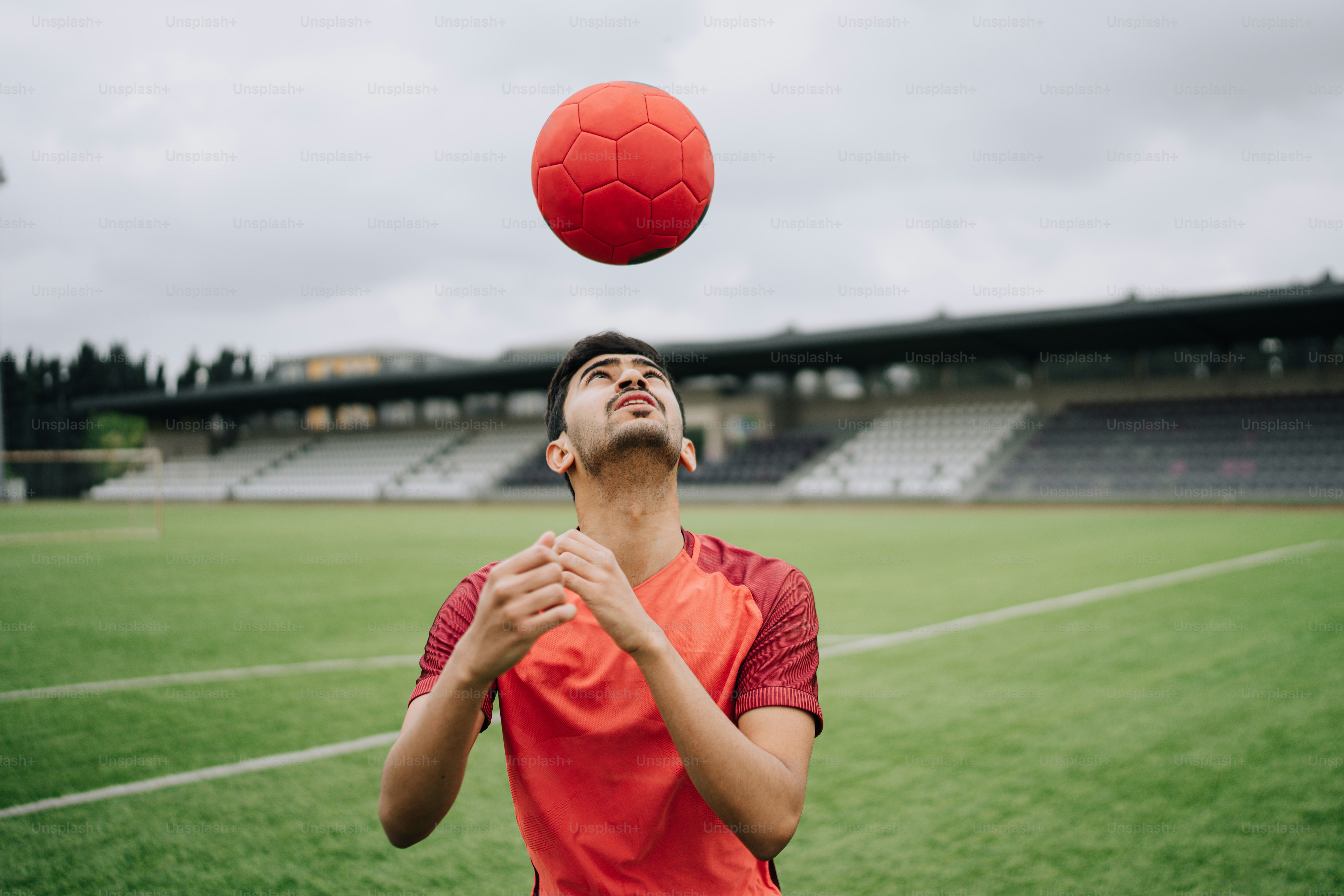A man is tossing a red ball in the air photo – Football Image on Unsplash