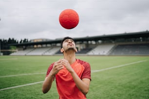 Ein Mann wirft einen roten Ball in die Luft