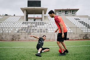 a couple of men standing on top of a soccer field
