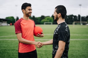 two men shaking hands on a soccer field