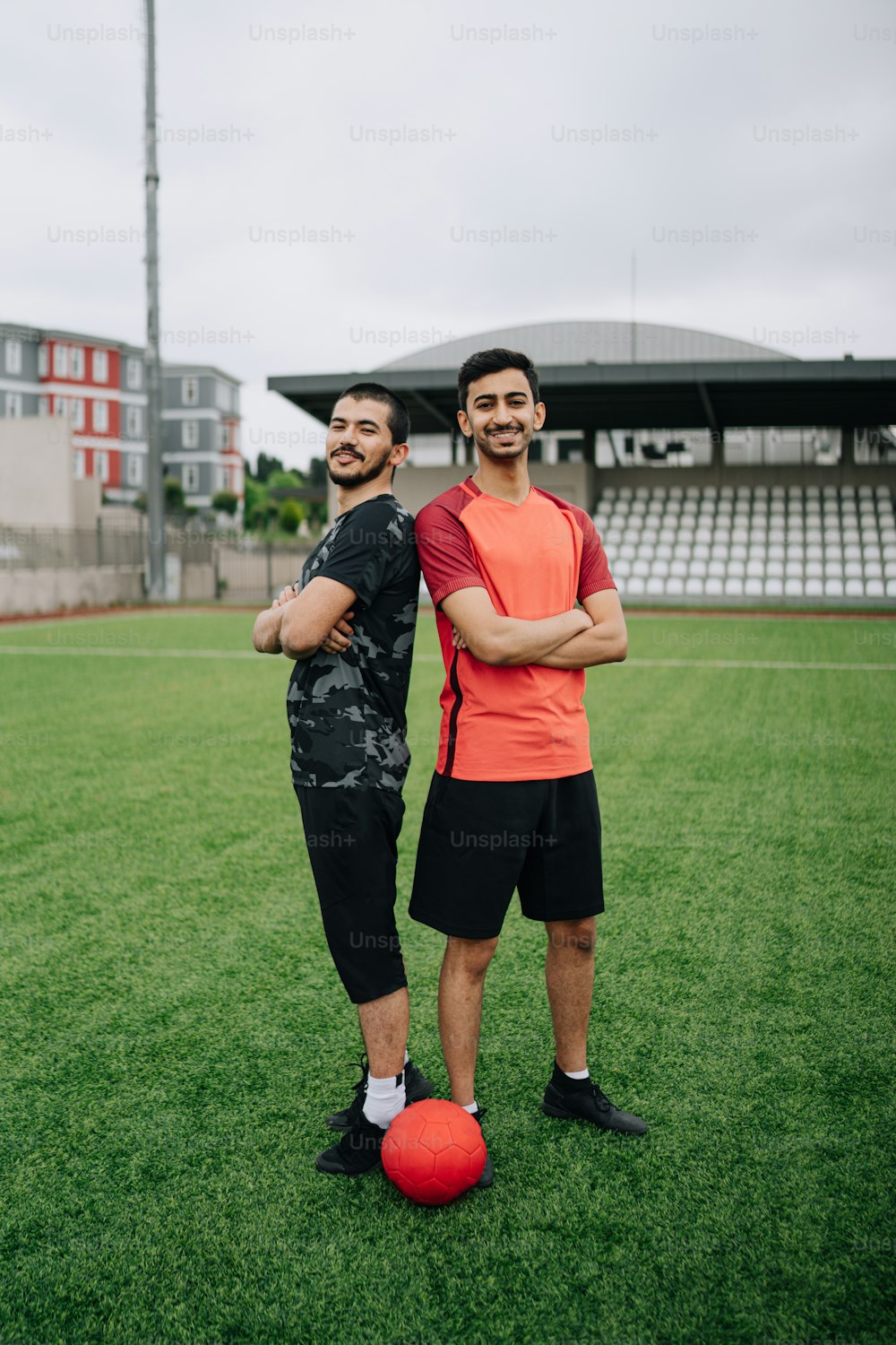 two men standing next to each other on a soccer field