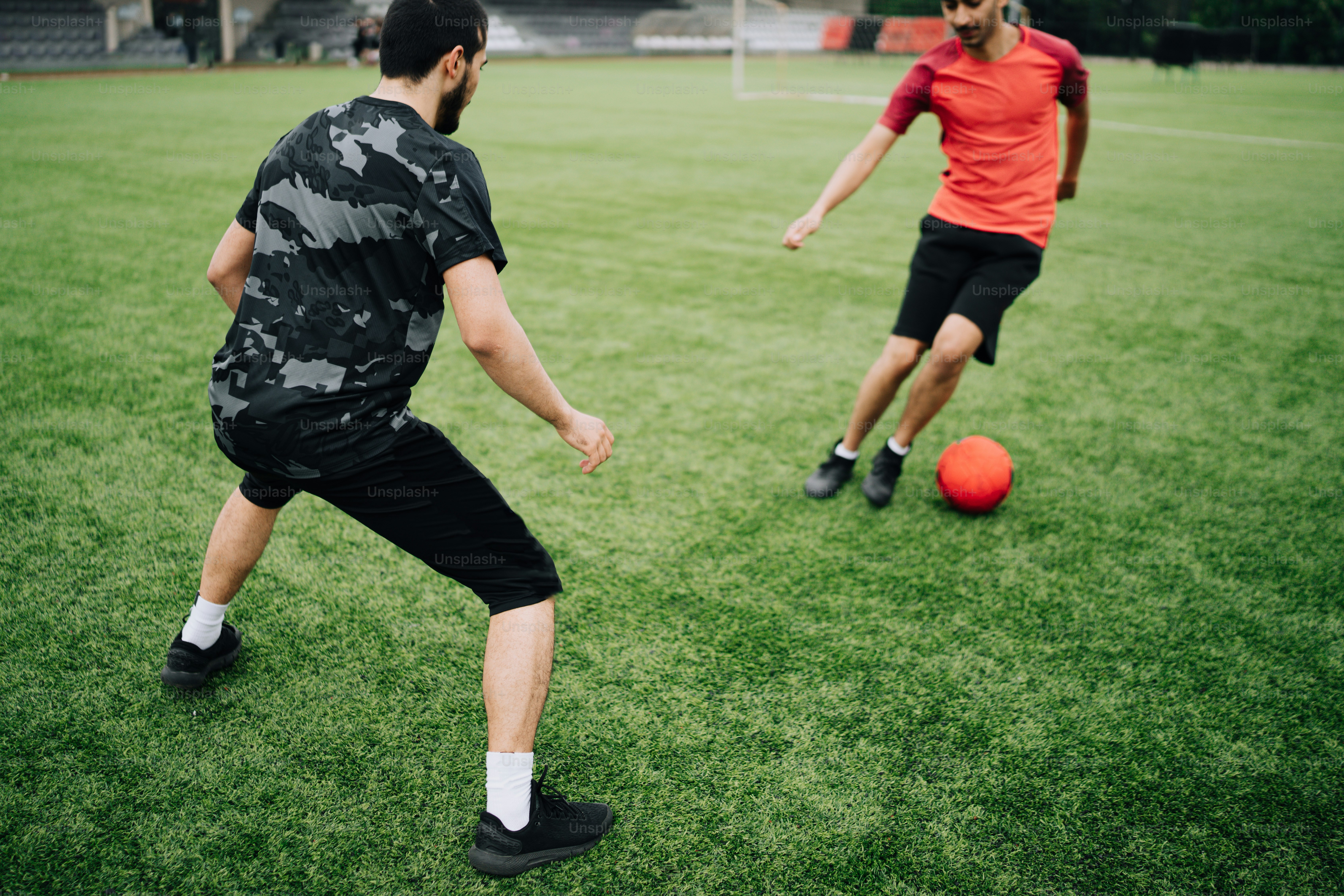 a couple of men standing on top of a lush green field