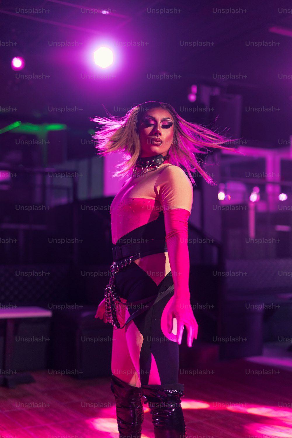 a woman in a black and pink outfit on a stage