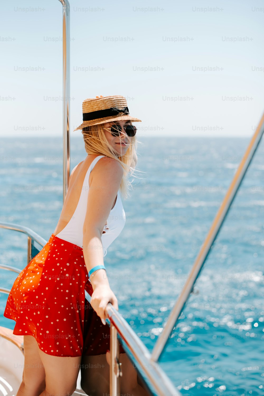 uma mulher usando um chapéu e óculos escuros em um barco