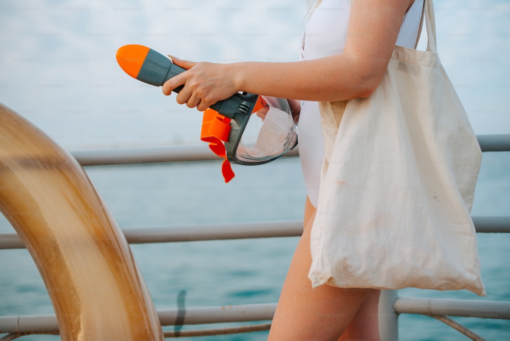 Una mujer sosteniendo un secador de pelo en un bote
