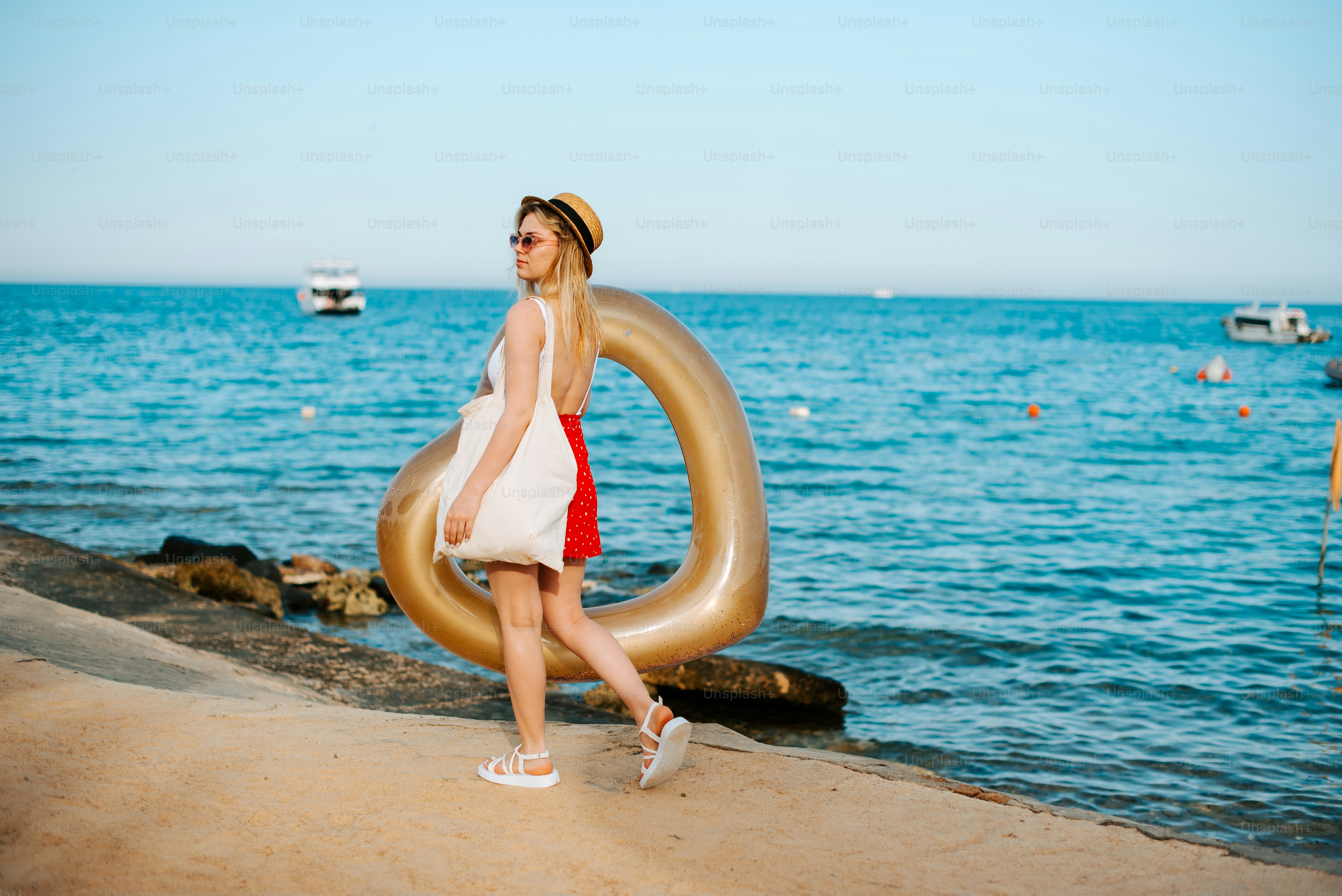 A woman in a white dress is walking by the water photo – Beach Image on ...