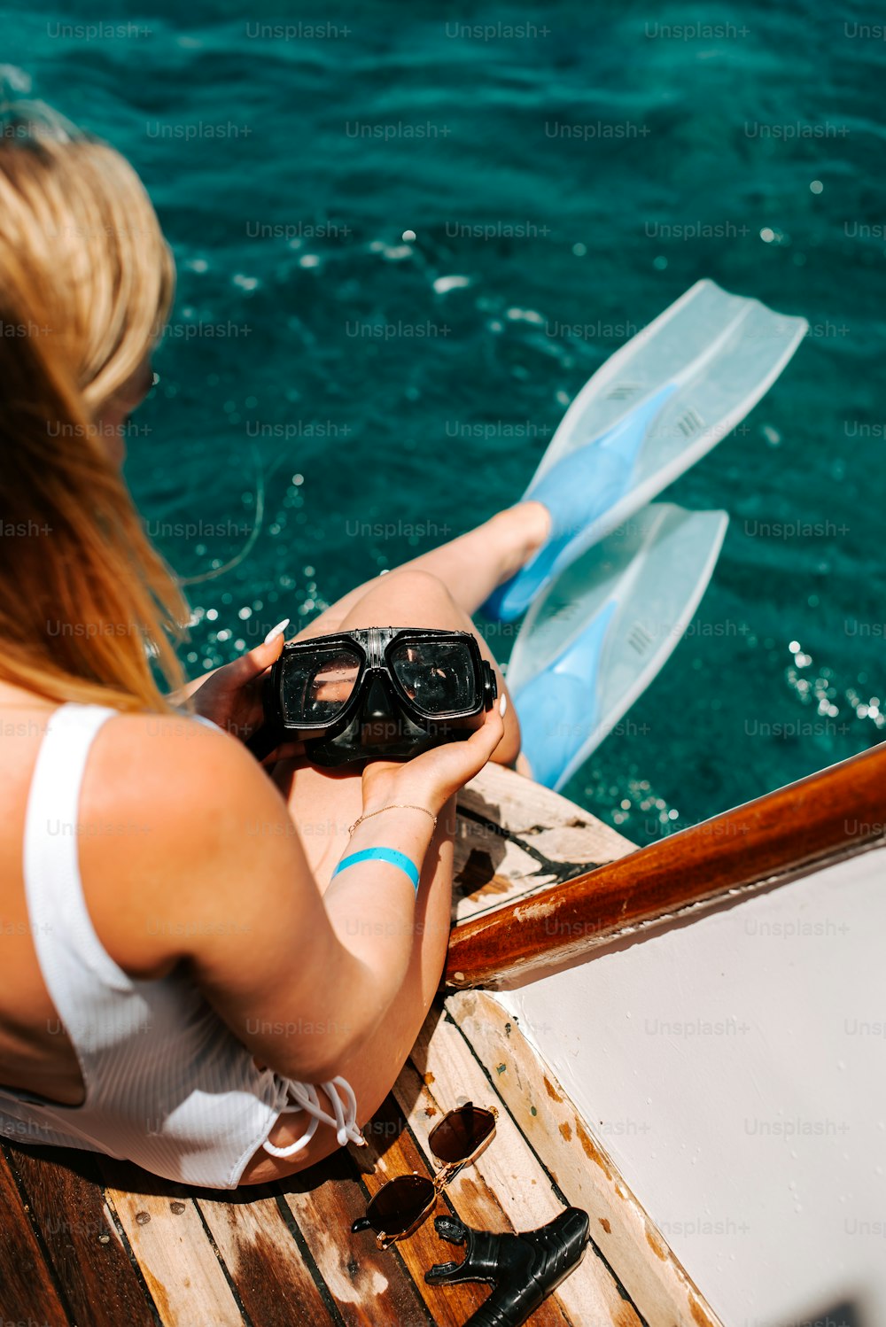Eine Frau, die auf einem Boot sitzt und eine Schutzbrille hält