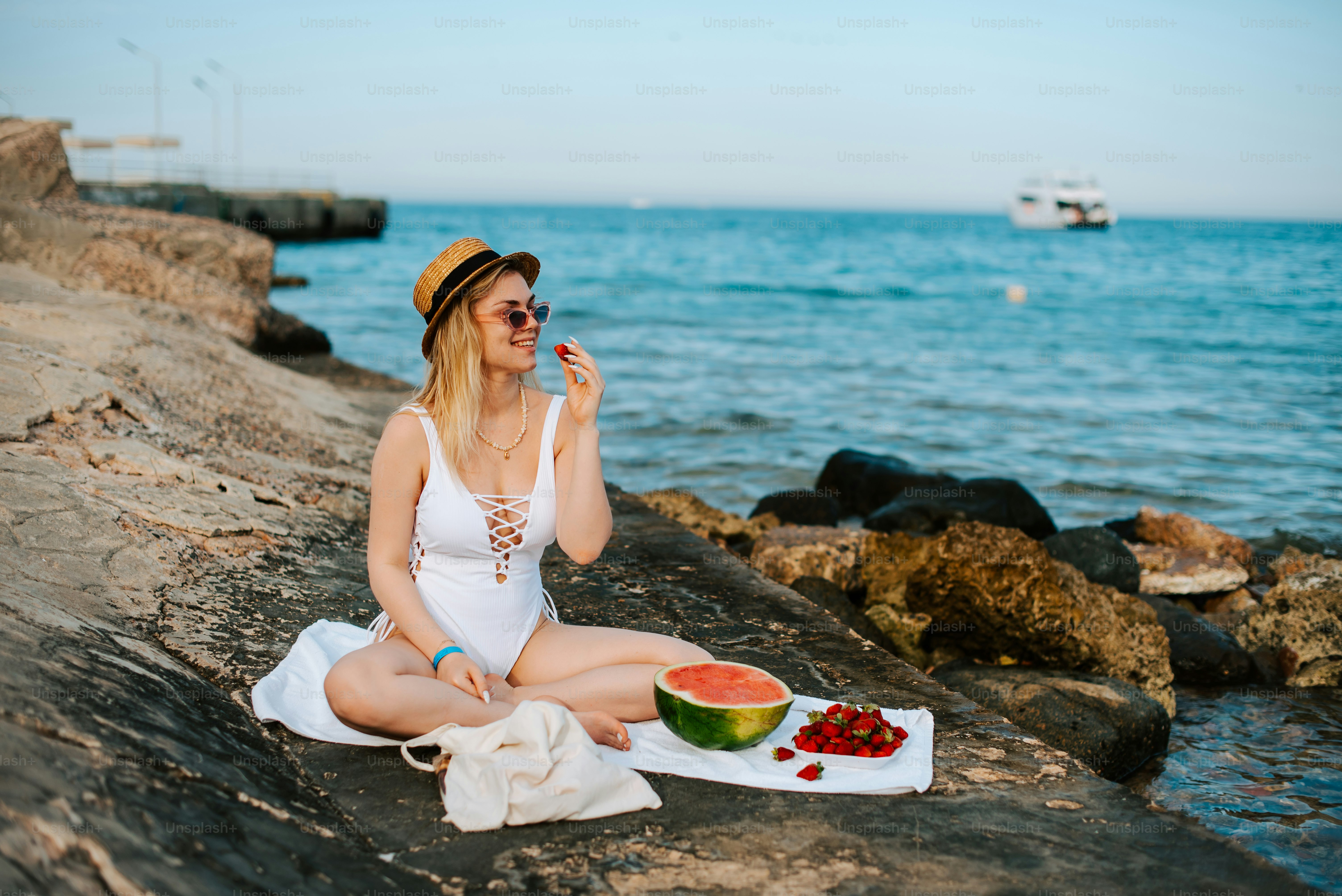 바다 옆 바위에 앉아 있는 여자