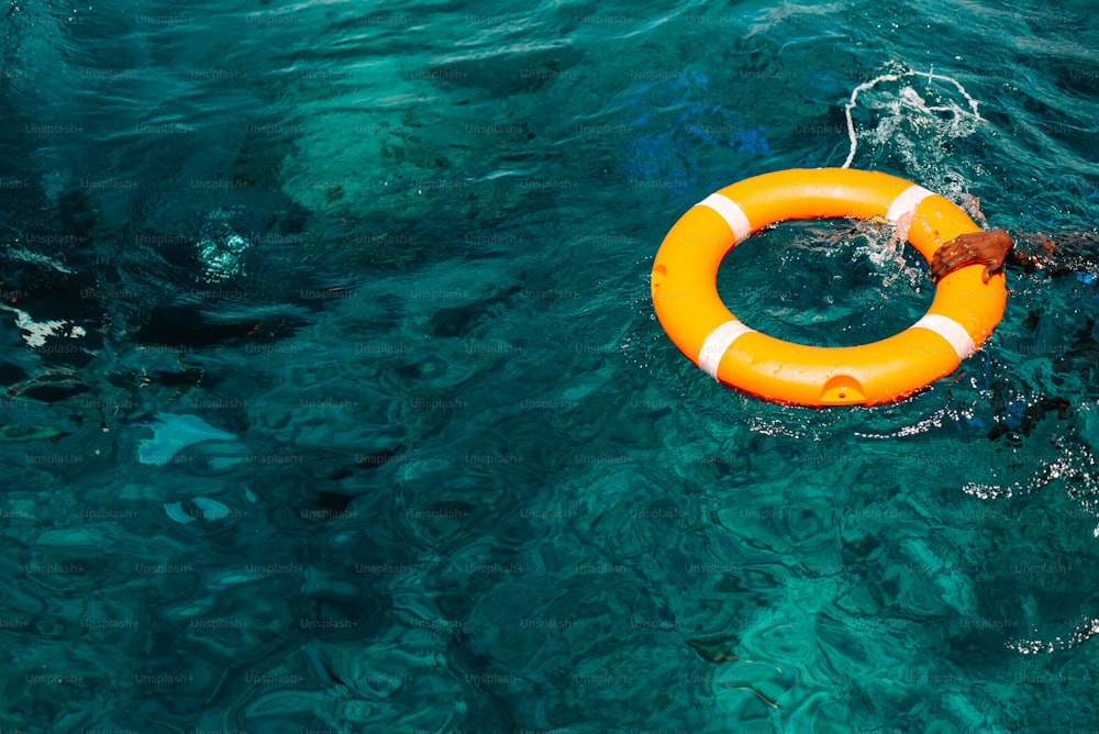 an orange life preserver floating in the ocean