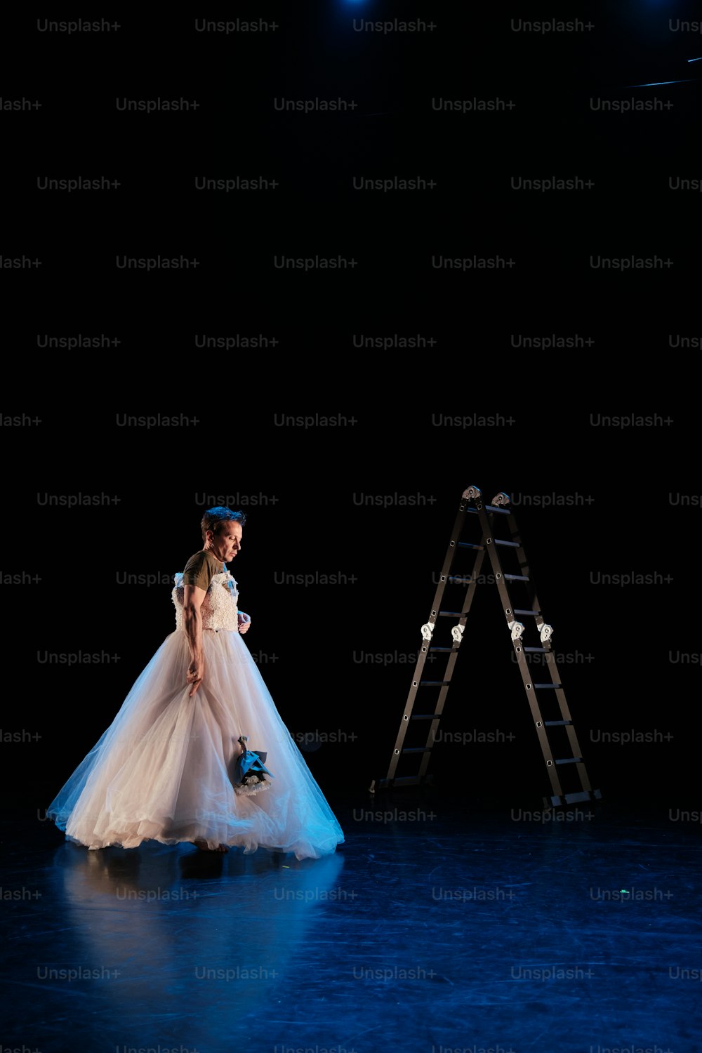 はしごの横に立っている白いドレスを着た女性