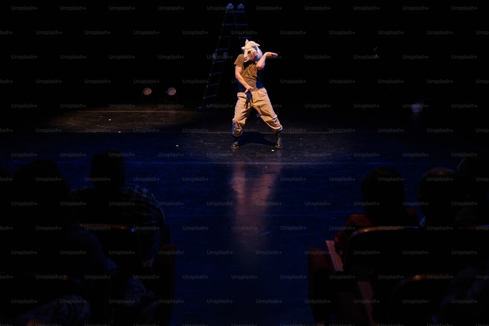 Un hombre en un escenario haciendo un truco en un monopatín