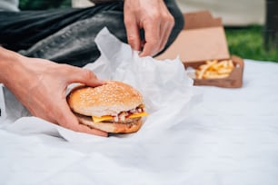 a person holding a hamburger in their hand