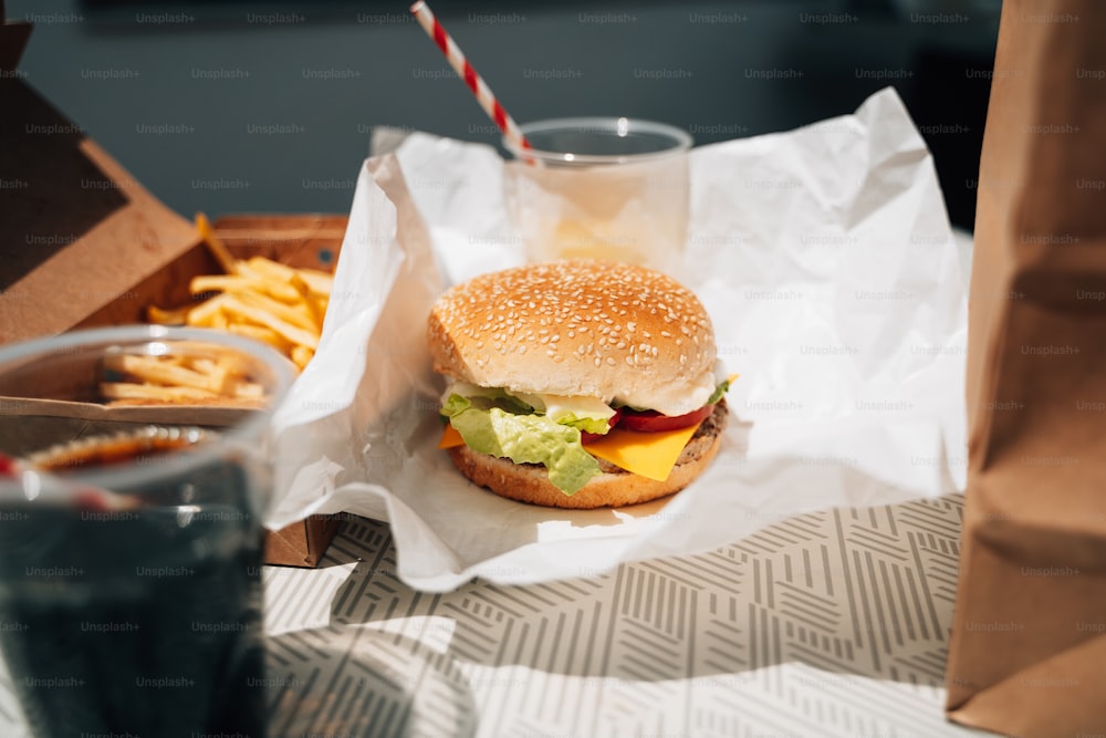 un hamburger et des frites sur une table avec une boisson
