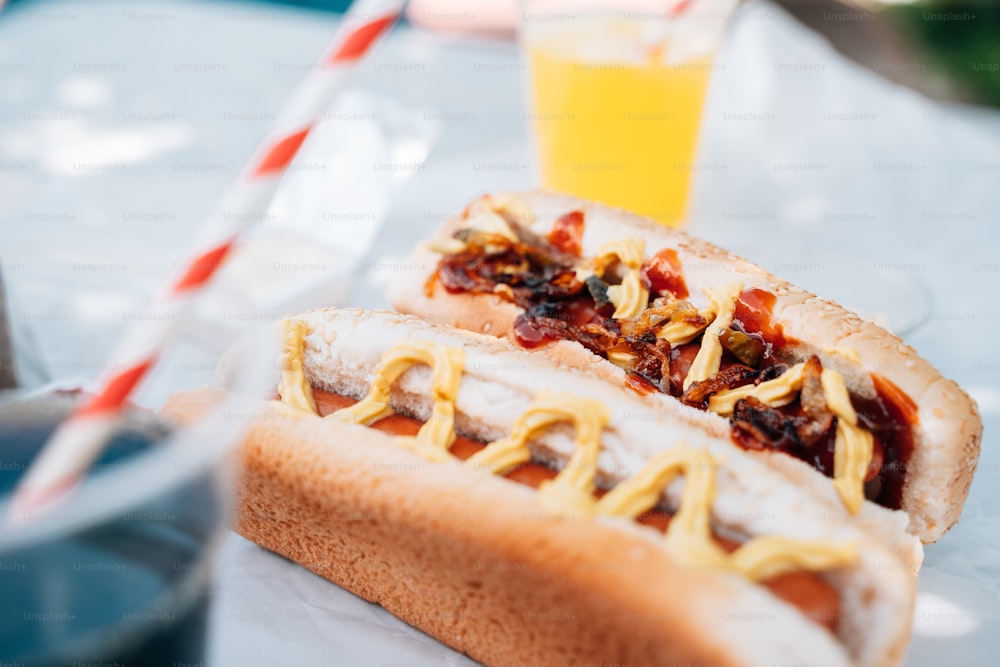 Deux hot-dogs sur un petit pain avec des condiments et une boisson